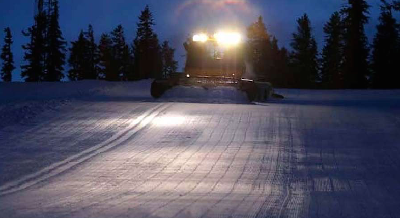 Ski piste and groomer showing prepaired snow